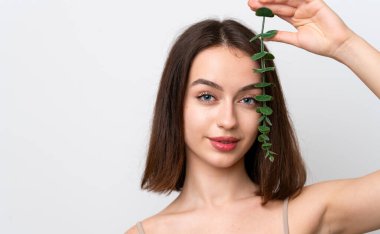 Beyaz arka planda izole edilmiş genç Ukraynalı kadın bir okaliptüs dalı tutuyor. Portreyi kapat