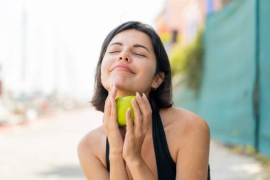 Açık havada elinde elma tutan genç, güzel bir Bulgar kadın.