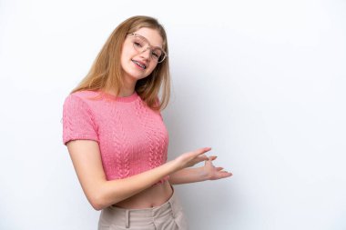 Beyaz arka planda izole edilmiş genç bir Rus kızı davet etmek için ellerini yana uzatıyor.