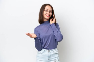 Beyaz arka planda izole edilmiş genç Ukraynalı bir kadın cep telefonuyla sohbet ediyor.