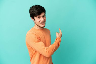 Genç Rus adam mavi arka planda izole edildi.