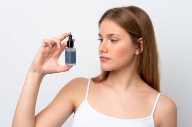 Beyaz arka planda izole edilmiş beyaz bir kadın elinde bir serum tutuyor. Portreyi kapat