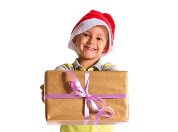 Enfant avec chapeau de Noël donnant un grand cadeau jaune — Photo