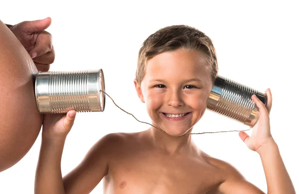 Criança conversando com seu futuro irmão através de um telefone de lata — Fotografia de Stock
