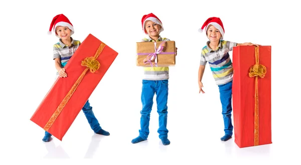 Enfant avec chapeau de Noël tenant un grand cadeau rouge — Photo