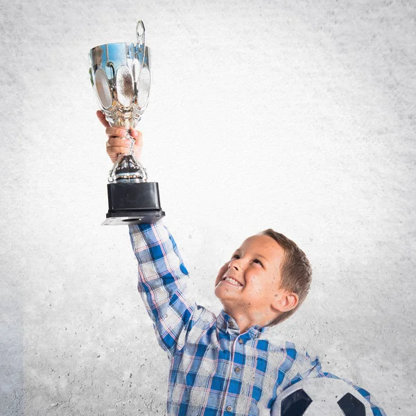 Niño sosteniendo un trofeo de fútbol —  Fotos de Stock