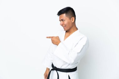 Genç Ekvador 'lu adam beyaz arka planda karate yapıyor. Parmakla göstererek bir ürün sunuyor.