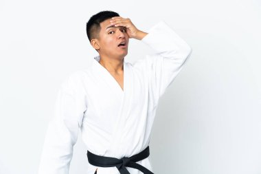 Beyaz arka planda karate yapan genç Ekvador 'lu adam, yandan bakarken sürpriz jest yapıyor.