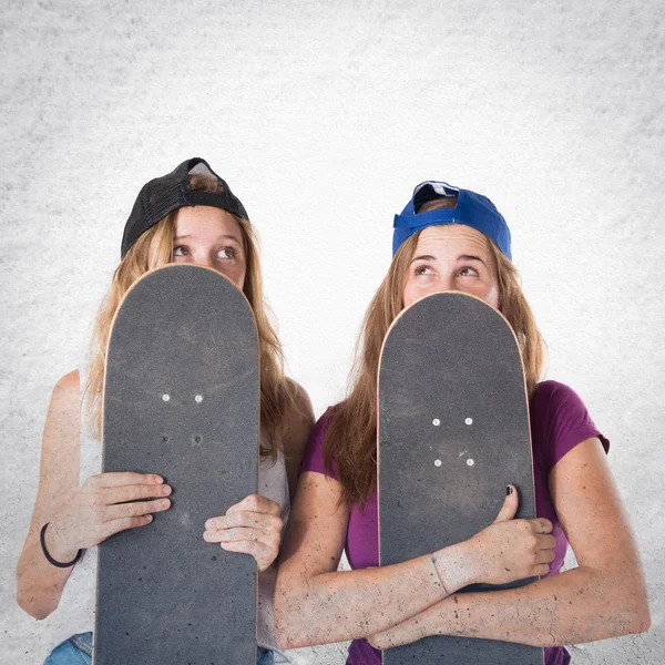 Meninas se escondendo atrás de seus skates — Fotografia de Stock