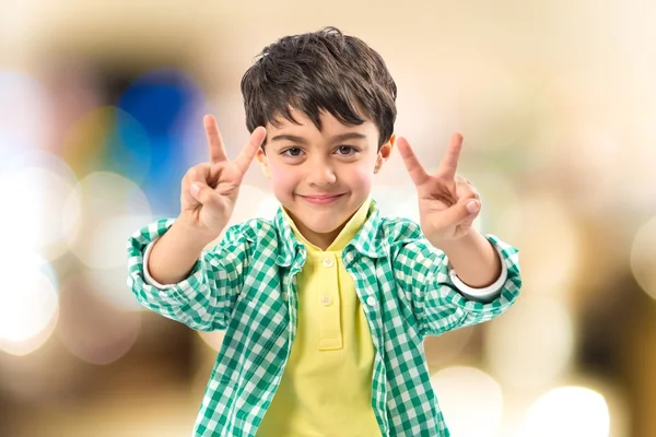 Boy making a victory sign over white background — Stock Photo, Image