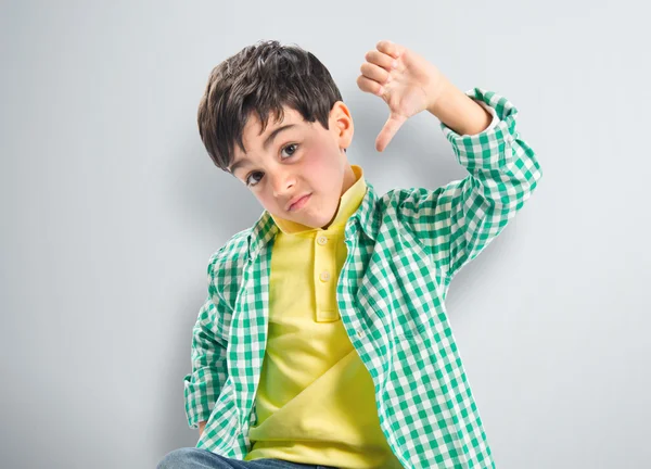 Niño haciendo mala señal sobre fondo blanco —  Fotos de Stock