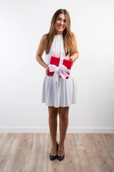 Bir hediye holding beyaz elbiseli güzel kız — Stok fotoğraf