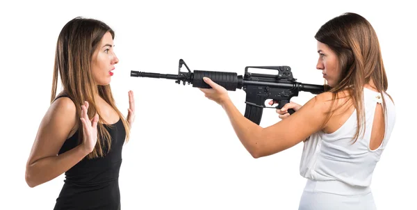 Woman pointing with a rifle at her sister — Stock Photo, Image