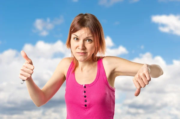 Jonge roodharige maken van een goed-bad teken op witte achtergrond — Stockfoto