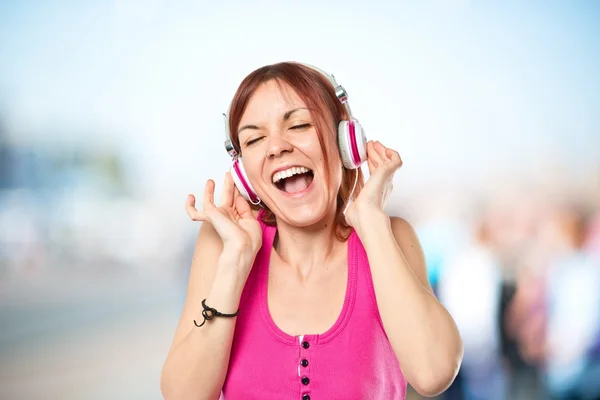 Young girl listening music over white background — Stock Photo, Image