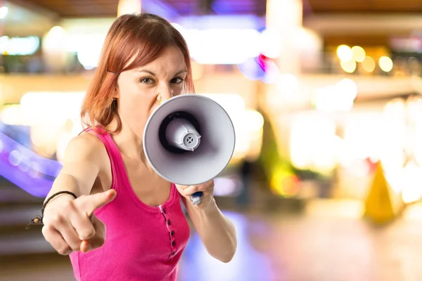 Roodharige meisje geschreeuw met een megafoon op witte achtergrond — Stockfoto