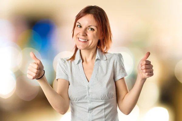 Pretty young girl with thumbs up over white background — Stock Photo, Image