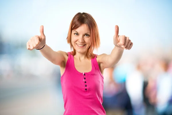 Pretty young girl with thumbs up over white background — Stock Photo, Image