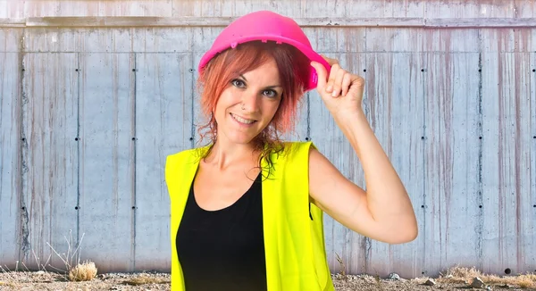 Vrouw werknemer met roze helm op witte achtergrond — Stockfoto