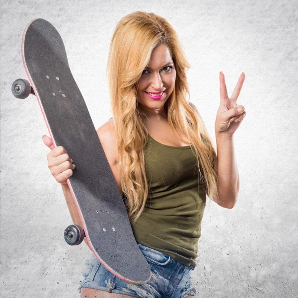 Skateboardista dívka dělá gesto vítězství — Stock fotografie