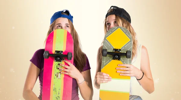 Les filles se cachent derrière leurs planches à roulettes — Photo