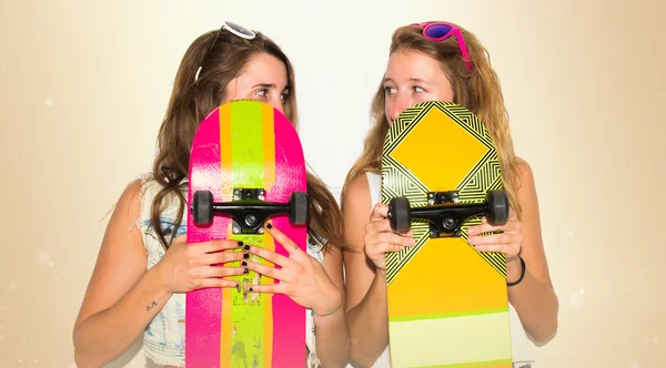 Dos amigos escondidos detrás de sus patinetas —  Fotos de Stock