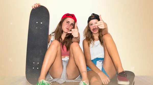 Amici con i loro skateboard fare gesto corno — Foto Stock