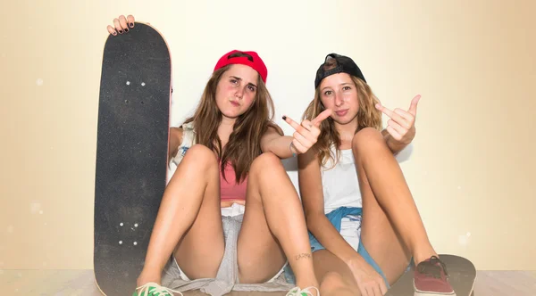 Amici con i loro skateboard fare gesto corno — Foto Stock
