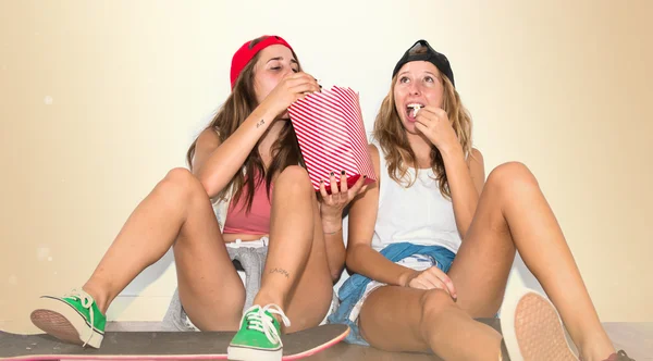 Amis avec leurs planches à roulettes manger popcorns — Photo