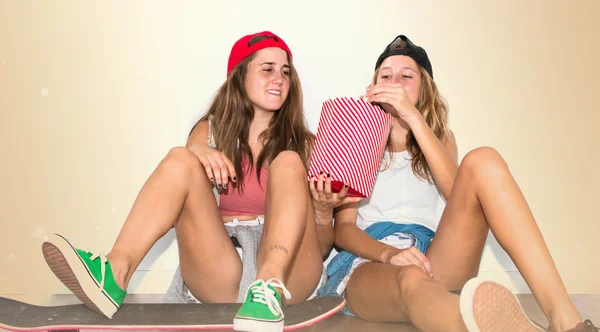 Amigos com seus skates comendo pipocas — Fotografia de Stock