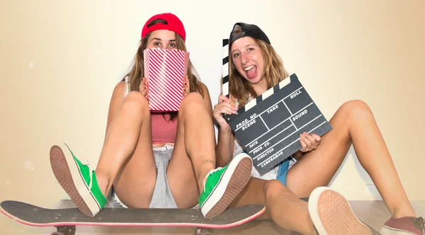 Vrienden met hun skateboards eten popcorns — Stockfoto