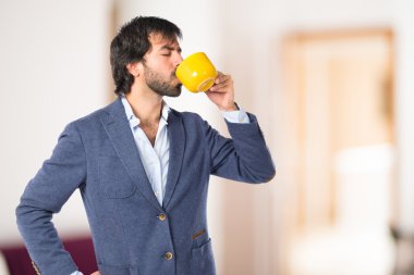 Bir fincan kahve beyaz arka plan üzerinde tutan işadamı 