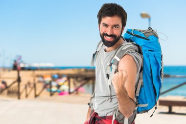Şanslı backpacker izole beyaz arka plan üzerinde 
