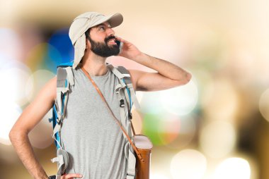 Beyaz arka plan üzerinde konuşmak için telefon backpacker