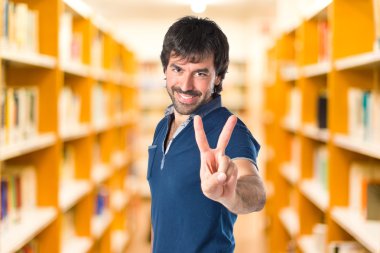 Beyaz arka plan üzerinde zafer hareketi yapan erkek