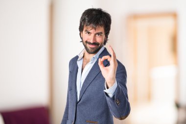 Beyaz arka plan üzerinde oturum Tamam yapma işadamı