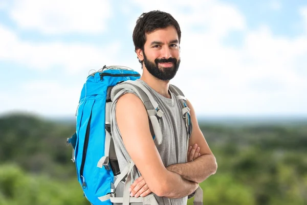 Backpacker mit verschränkten Armen vor weißem Hintergrund — Stockfoto