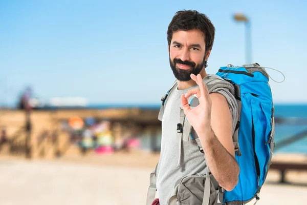 Backpacker κάνοντας Ok υπογράψει πάνω από το λευκό φόντο — Φωτογραφία Αρχείου