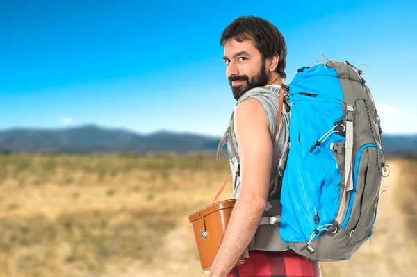 Giovane zaino in spalla camminando su sfondo bianco — Foto Stock