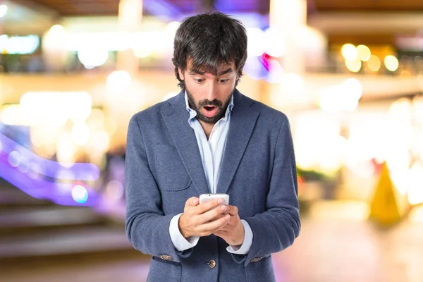 Hombre sorprendido hablando con móvil sobre fondo blanco —  Fotos de Stock