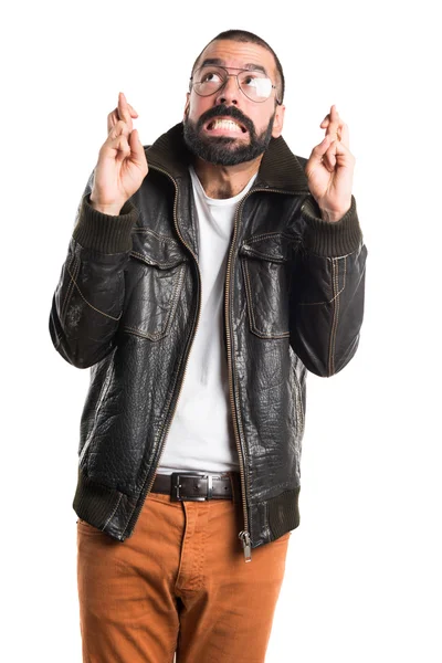 Человек в кожаной куртке со скрещенными пальцами — стоковое фото