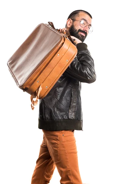 Muž na sobě koženou bundu konání kufru — Stock fotografie