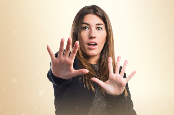 Pretty brunette girl over ocher background