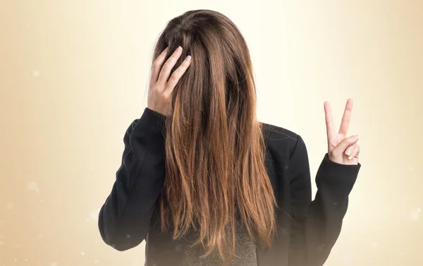 Mädchen macht Siegesgeste mit Haaren im Gesicht — Stockfoto