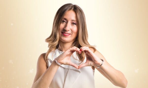 Женщина создаёт сердце своими руками