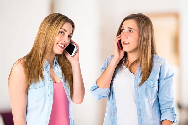 Genç kızlar beyaz arka plan üzerinde konuşmak için telefon — Stok fotoğraf