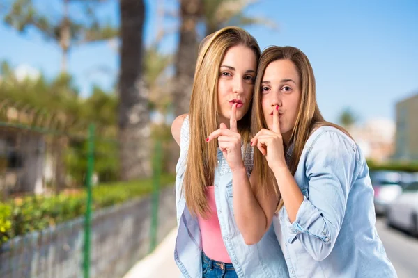 Friends making silence gesture over isolated white background — Stock Photo, Image