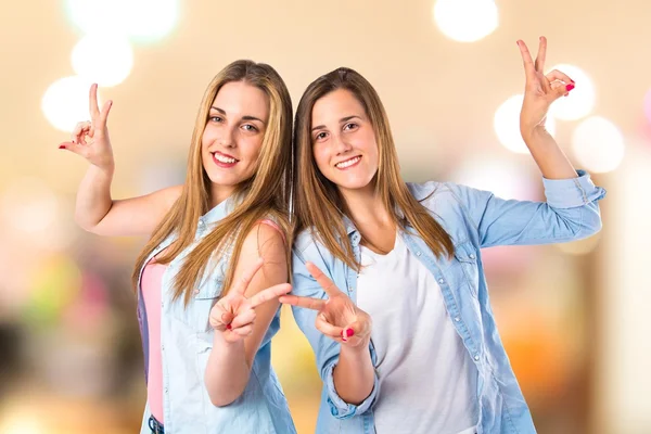 Mädchen machen Siegesgeste vor weißem Hintergrund — Stockfoto