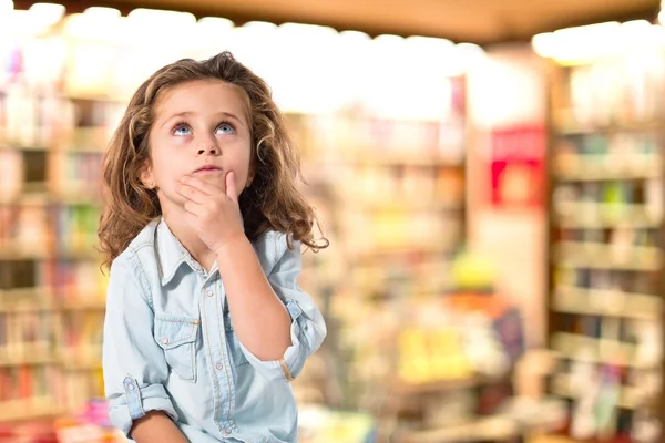 Blonde little girl thinking over white background — Stock Photo, Image