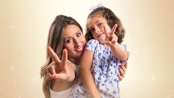 Mother and daughter doing victory gesture — Stock Photo, Image